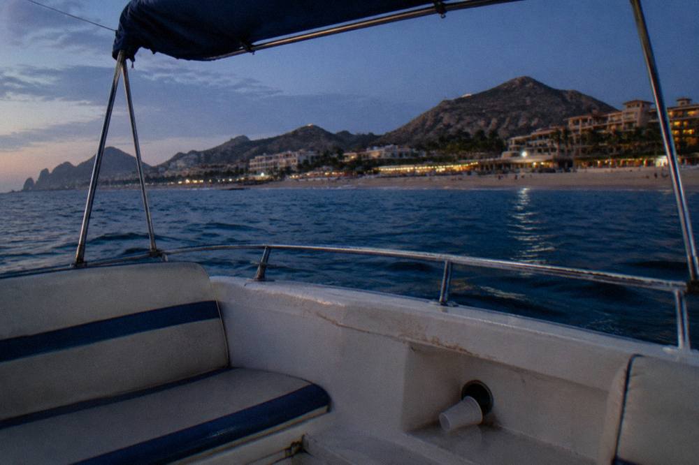 Open deck of a boat at dusk with railings and seat cushions in soft evening light
