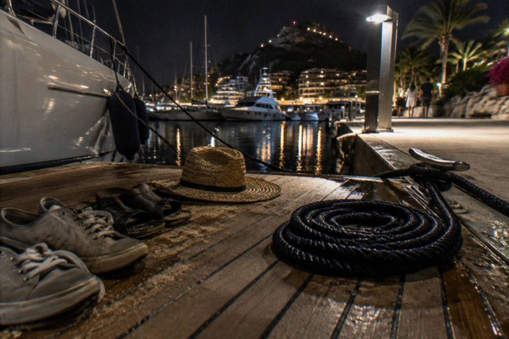 Sneakers and sandals drying on the slatted deck of a small boat in warm light