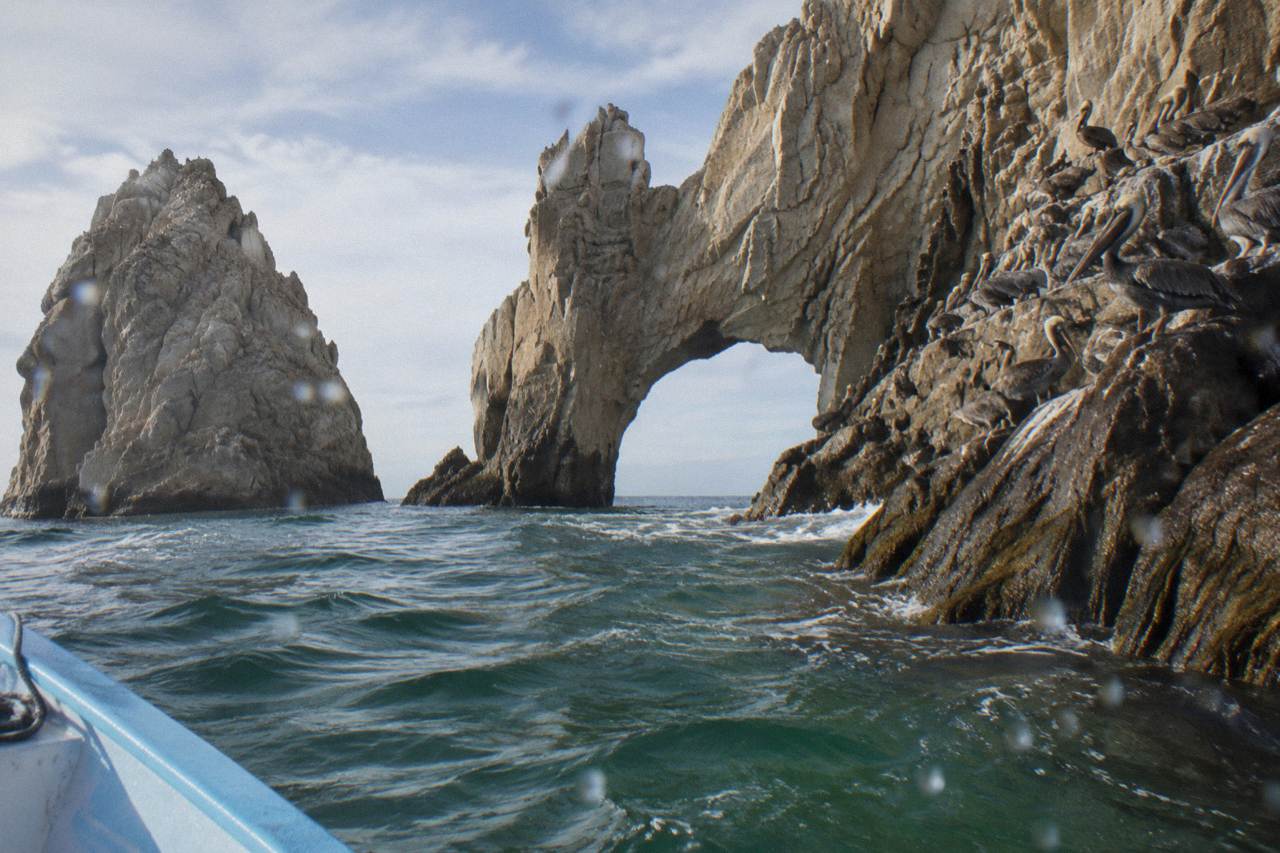 Granite rock arch at Land's End rising above calm Pacific water near Cabo San Lucas