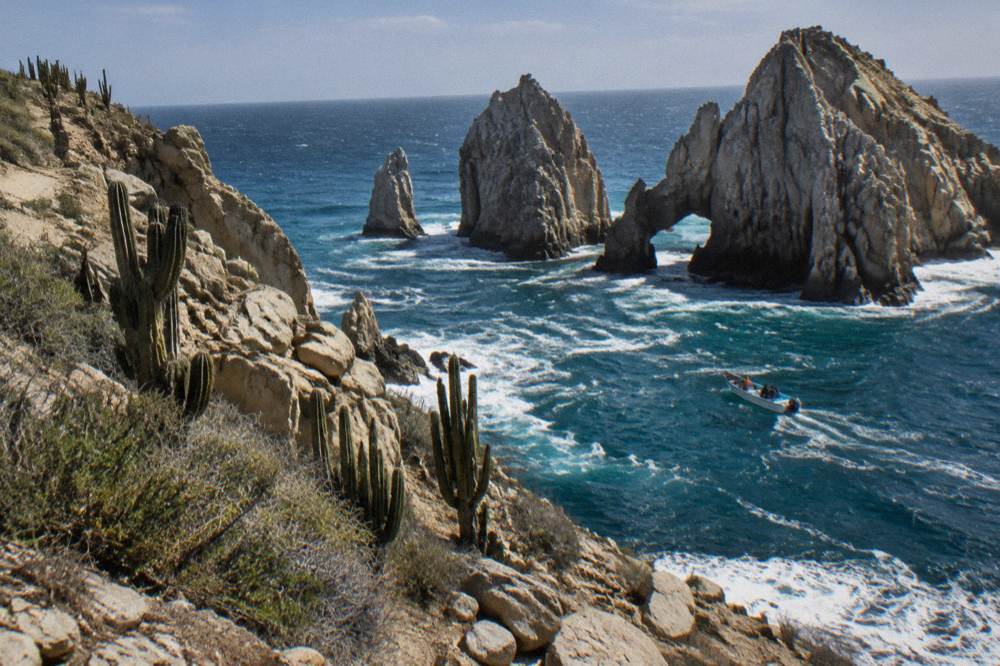 Small boat cruising close to the rock formations at Land's End in Cabo San Lucas