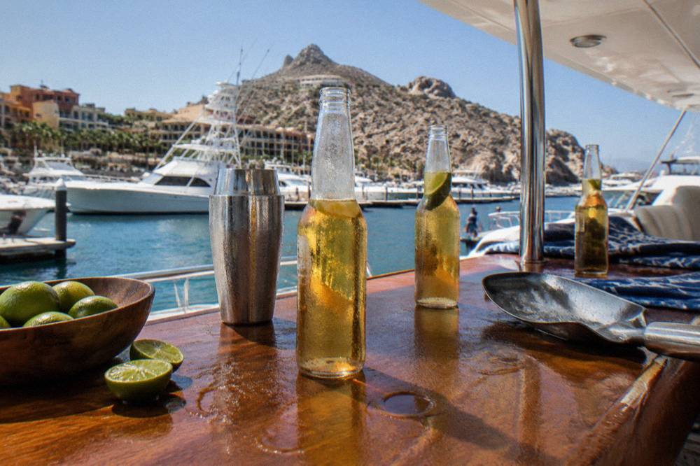 Cocktails and beer bottles lined up on a boat bar counter
