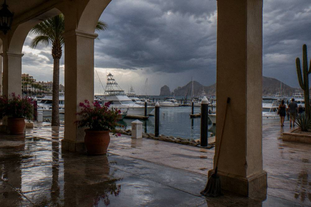 Dark storm clouds gathering over the sea horizon beyond a calm marina with moored boats