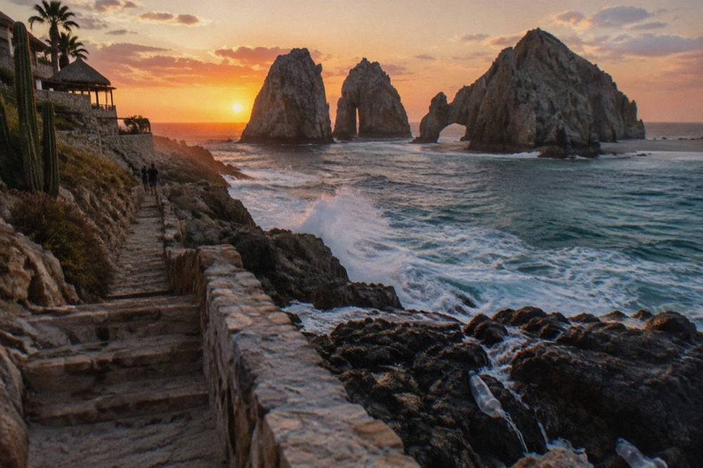 Sun setting over the Pacific behind the rock formations at Land's End seen from a cliffside viewpoint