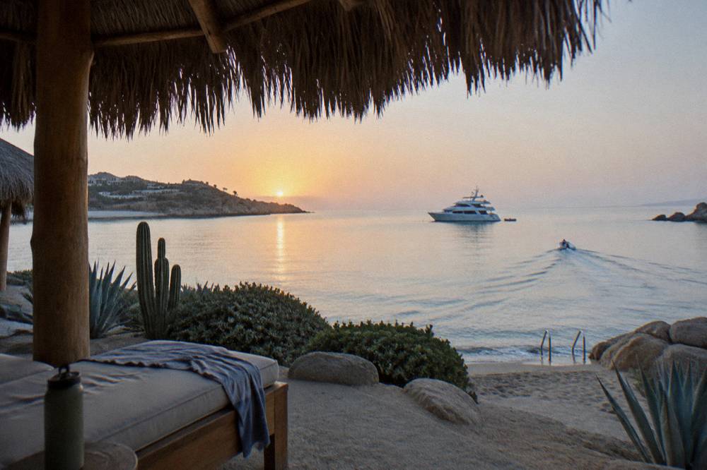 Private yacht anchored in a quiet bay with rocky shoreline in the background